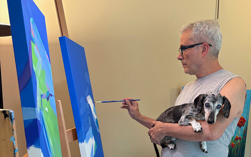 Painter holding a dog