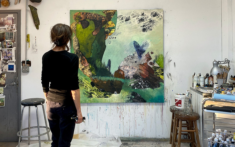 An artist looking at a green painting